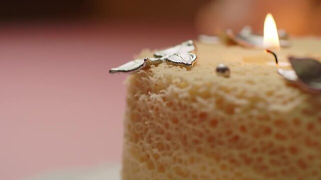 Celebration Cake With Silver Leaf Decoration And A Burning Candle