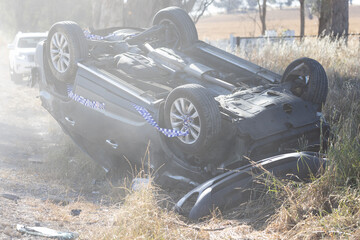 Damaged and overturned car on the roadside after accident