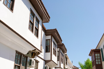 Row of brown and white buildings with brown shutters