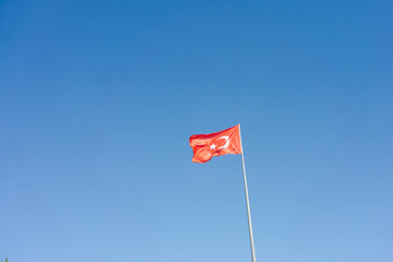Red flag with a white star on it is flying in the sky