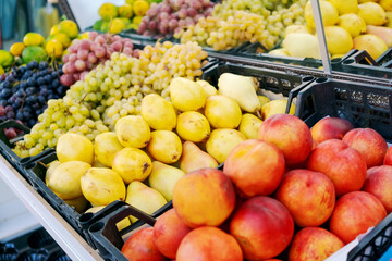 Fruit stand with a variety of fruits including apples, oranges, and pears