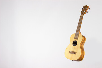 Fototapeta premium Ukulele on a white background. A guitar made of light wood on a white background. isolated, front view.