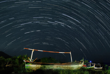 Star Trails Over Abandoned Boat at Night with Stunning Night Sky