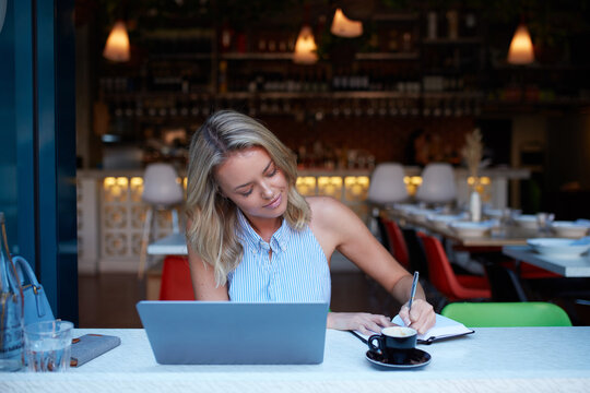 Young woman freelancing from her laptop at cafe