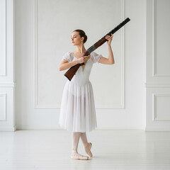 Ballet girl dancing or posing with shotgun in dance hall