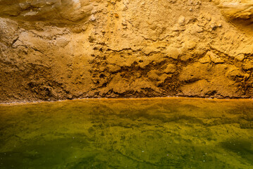 Sand quarry filled with water reflecting the cloudy sky, creating an industrial yet natural landscape