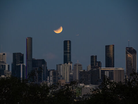 Eclipse of the full moon shining over city skyline - Powered by Adobe