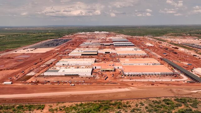 Drone aerial view of hyperscale data center construction with steel framework, cranes, and machinery, highlighting technology infrastructure development in progress.