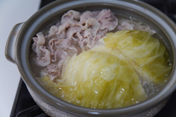 キャベツと豚肉の鍋を作る様子