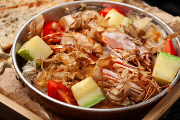 Delicious seafood stew with fresh vegetables served in a rustic bowl at a cozy dining setting