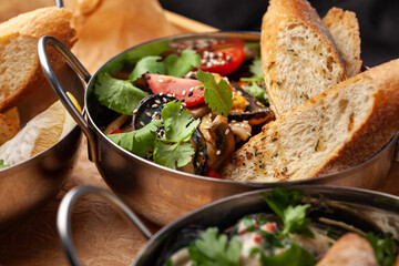 Flavorful vegetable dish with grilled ingredients and fresh herbs served with bread