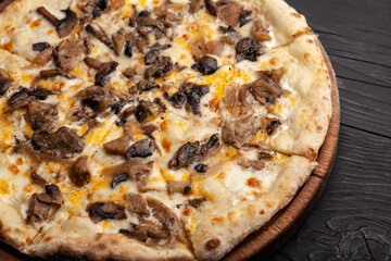 Delicious mushroom pizza served on a wooden plate in cozy dining setting
