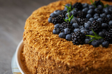 Delicious cake topped with blackberries and blueberries on a decorative plate