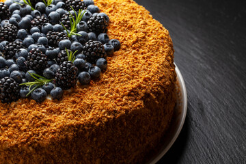 Delicious dessert with a crunchy topping and fresh berries served on a dark background