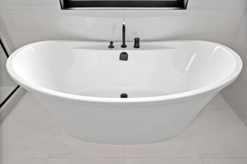Large white bathtub with a black faucet