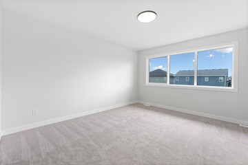 Large, empty room with a window and a light fixture