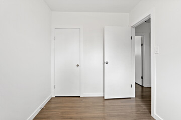 Small, empty room with white walls and wooden floors
