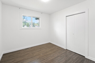 White room with a wooden floor and a window