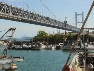 The Seto Ohashi Bridge is a series of interconnected spans that appear to wind across the islands of the Seto Inland Sea.
This image was taken from the fishing village beneath it.