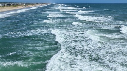 Vacation by the beach in the Outer Banks, NC watching sunlight on ocean waves and surf on a summer morning while relaxing in the sunshine