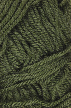 Natural moss green fine wool skein threads texture, vertical textured clew macro closeup background pattern, large detailed woolen flat lay