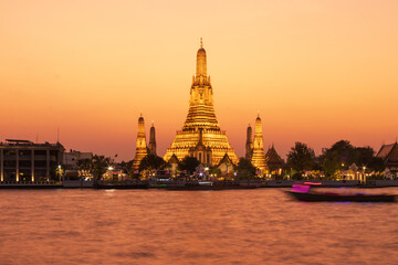 Fototapeta premium Wat Arun Ratchawararam Ratchawaramahawihan or Wat Arun (Temple of Dawn) is a Buddhist temple along the Chao Phraya river at twilight in Bangkok, Thailand.