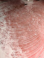 The red floor displays a striking pattern of white lines, creating a textured and intriguing abstract design.