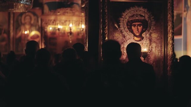 People gathering in Orthodox church during Easter night ceremony. The scene depicts a figure facing religious icons adorned with candles