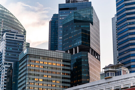 Urban skyline at golden hour with illuminated workspaces, Singapore, Asia