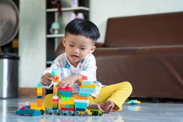 Fototapeta premium Child Playing with Colorful Building Blocks Indoors