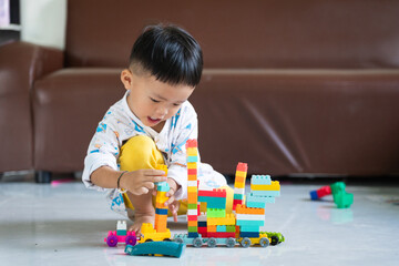Naklejka premium Child Playing with Colorful Building Blocks Indoors