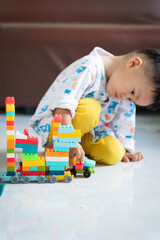 Fototapeta premium Child Playing with Colorful Building Blocks Indoors
