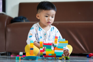 Fototapeta premium Child Playing with Colorful Building Blocks Indoors