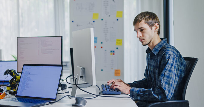 Young adult male freelance developer typing write prompt AI bot app program nomad terminal with coding at office. Artificial intelligence dashboard, robotics, user interface, machine learning concept. - Powered by Adobe