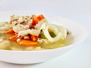 Nutritious Chicken Soup with Carrots and Cabbage in White Bowl Studio Shot.