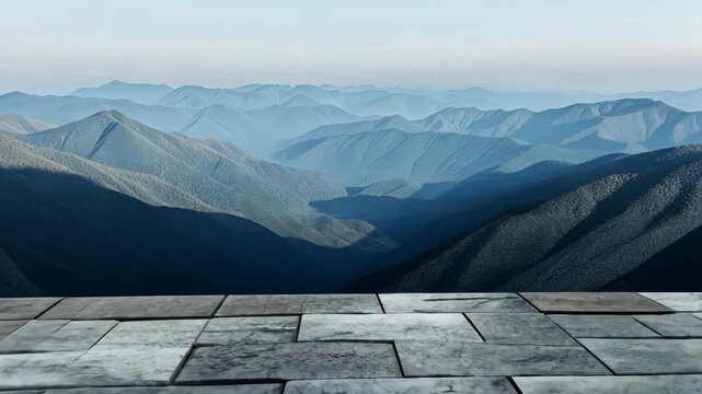 Expansive mountain ranges stretch into the horizon under a clear sky, visible from a sturdy stone terrace