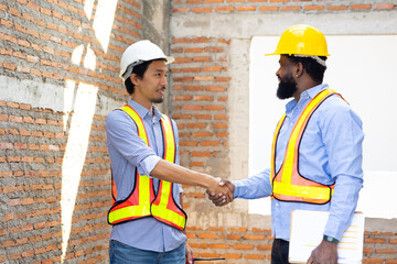Handshake Unity and teamwork : Male Engineering Architect and contractor People shaking hands on business cooperation agreement. Successful hand shaking after good deal. japanese and black man