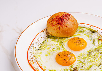 Delicious green sauce eggs served with a soft bread roll for breakfast