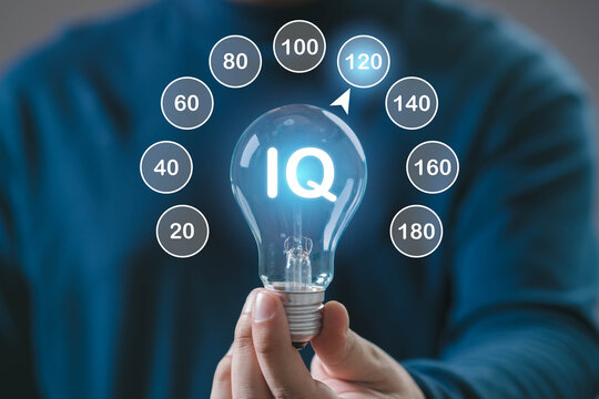 A person holds a light bulb displaying "IQ," surrounded by various IQ score indicators, symbolizing intelligence assessment.