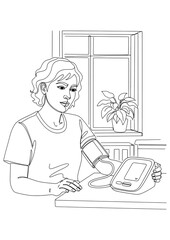 A woman is measuring her blood pressure at home.