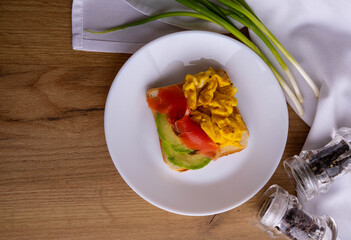 scrambled eggs with fish and avocado on toast. Delicious breakfast.