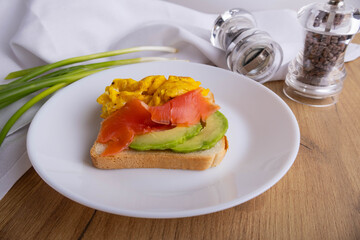scrambled eggs with fish and avocado on toast. Delicious breakfast.