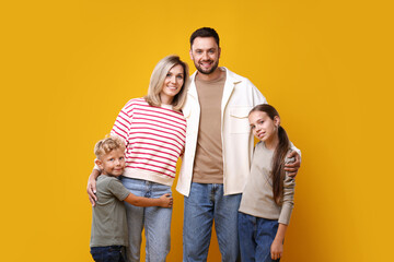 Obraz premium Family portrait of happy parents and their children on yellow background