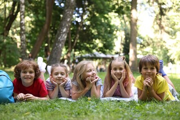 Cute little kids on green grass in park