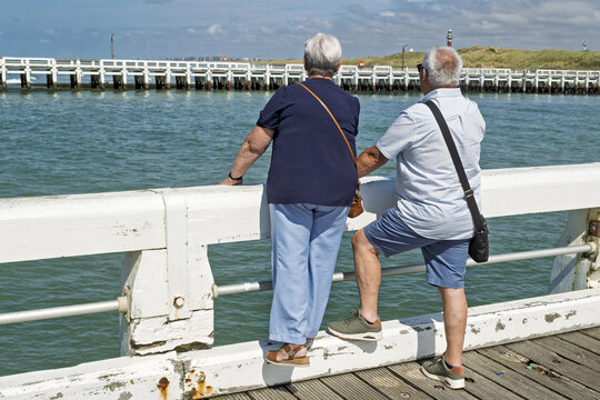 The river Yser flows into the North Sea at the town of Nieuwpoort between two wooden jetties, a walk on sunny days and on vacation