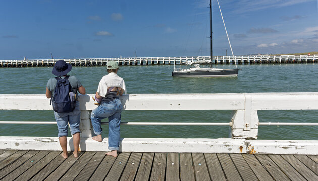 The river Yser flows into the North Sea at the town of Nieuwpoort between two wooden jetties, a walk on sunny days and on vacation