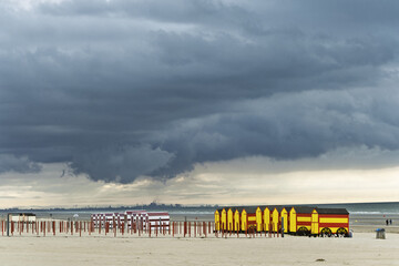 Fototapeta premium Row of red and yellow beach huts at sunset at De Panne, Belgium.