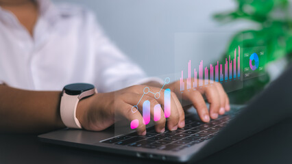 Data analysis, business growth, and digital technology solutions. Close-up of hands typing on a laptop with holographic bar graphs, charts, and analytics.