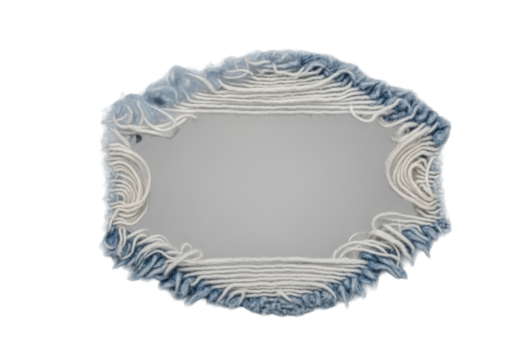 Extreme macro close-up of a circular ripped hole in worn indigo blue denim, showcasing inside-out texture, diagonal twill, and frayed threads on a transparent background. Concept of textile detail and