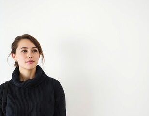 Fototapeta premium Portrait of a woman in a black turtleneck looking upward 